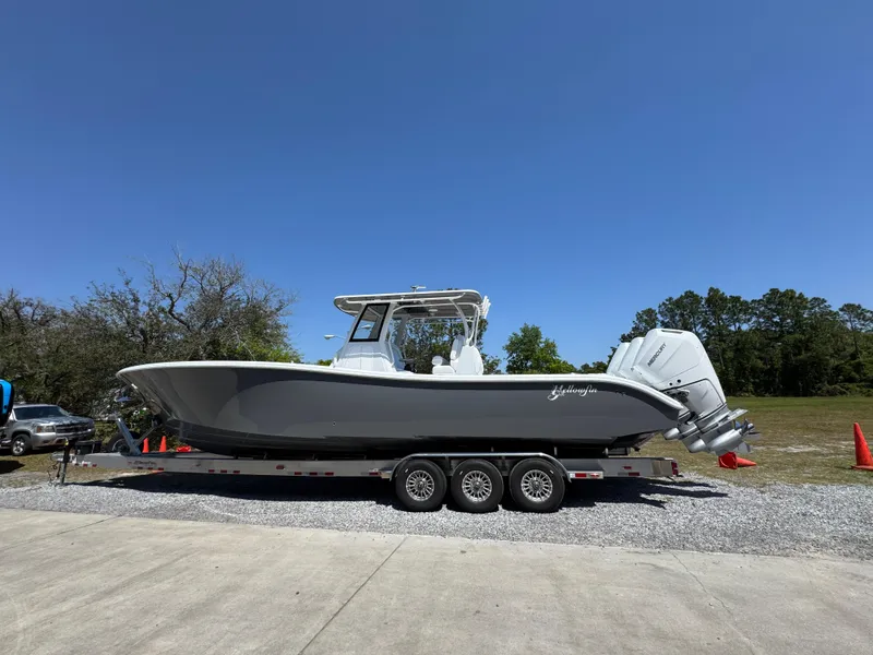 Slide: The Image of 2025 Yellowfin 36 Offshore boat on trailer under clear blue sky. - 14