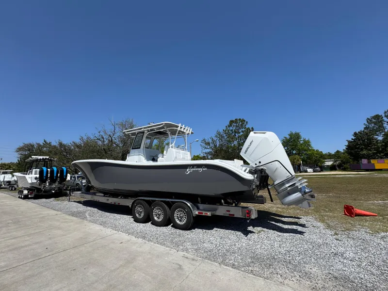 Slide: The Image of 2025 Yellowfin 36 Offshore boat on trailer, parked outdoors under clear blue sky. - 16
