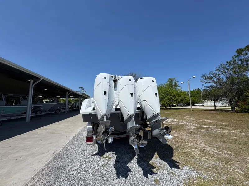 Slide: The Image of 2025 Yellowfin 36 Offshore boat with triple outboard engines, parked outdoors. - 20