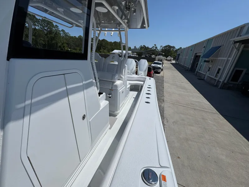 Slide: The Image of 2025 Yellowfin 36 Offshore boat, side view, docked near industrial buildings under clear sky. - 30