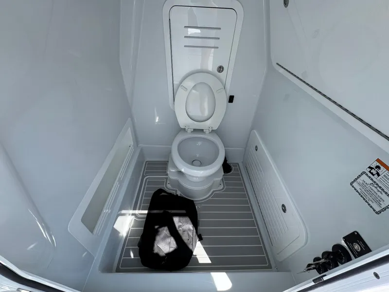 Slide: The Image of 2025 Yellowfin 36 Offshore boat bathroom with toilet and storage compartments. - 32