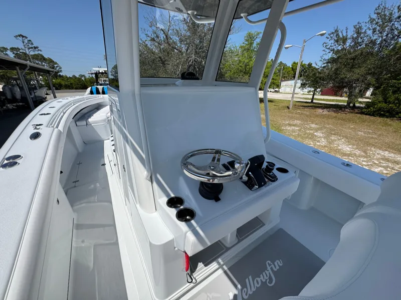 Slide: The Image of 2025 Yellowfin 36 Offshore boat cockpit with steering wheel and controls, docked outdoors. - 36