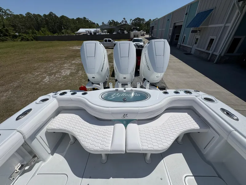 Slide: The Image of 2025 Yellowfin 36 Offshore boat with triple engines, docked near a warehouse. - 42