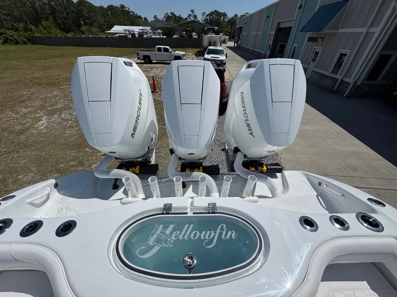 Slide: The Image of 2025 Yellowfin 36 Offshore boat with triple Mercury outboard engines, docked near a warehouse. - 45
