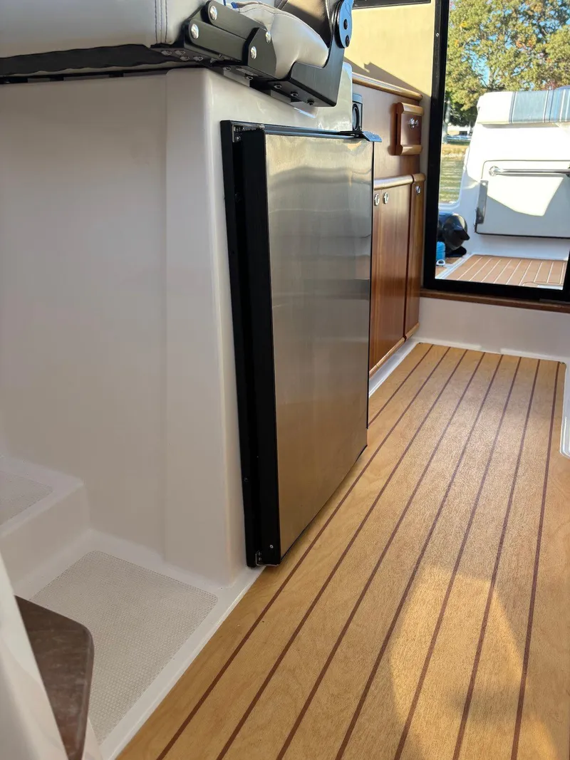 Slide: The Image of 2019 Cutwater C-242 Coupe interior with wood flooring and stainless steel appliances. - 13