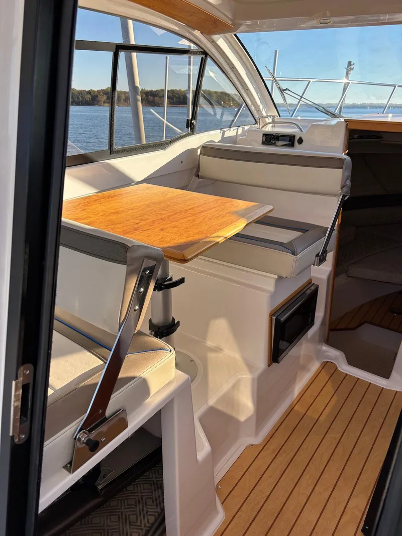 Slide: The Image of 2019 Cutwater C-242 Coupe interior with wooden table, seating, and scenic water view. - 16