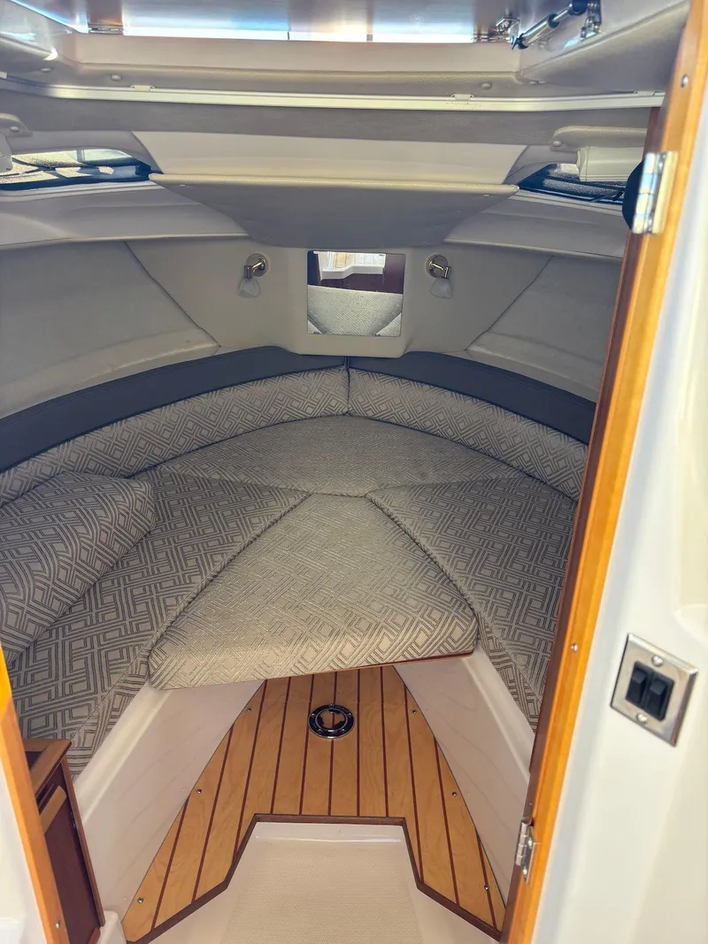 Slide: The Image of 2019 Cutwater C-242 Coupe cabin interior with cushioned seating and wooden flooring. - 17