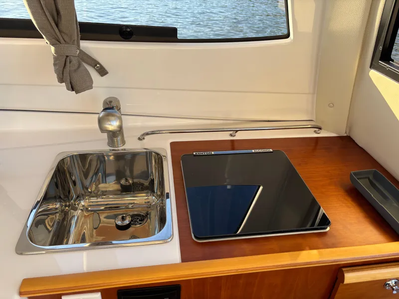 Slide: The Image of 2019 Cutwater C-242 Coupe interior with sink and stove in compact kitchen area. - 20