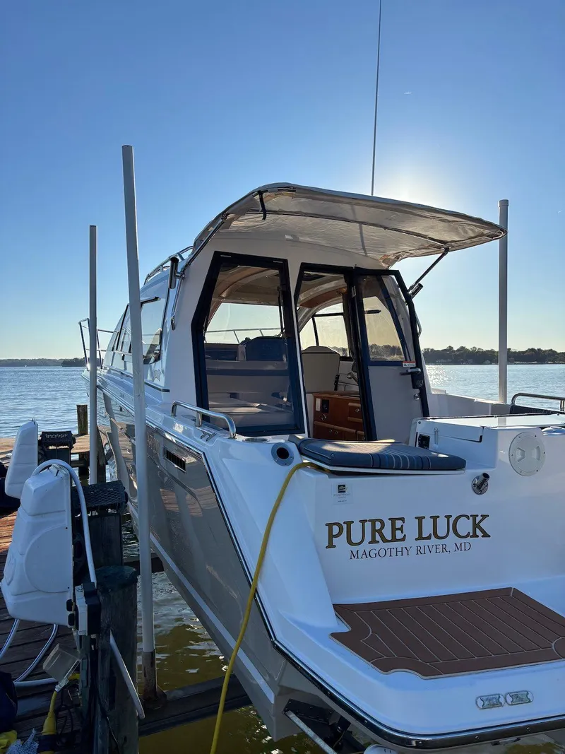 Slide: The Image of 2019 Cutwater C-242 Coupe boat docked, named "Pure Luck," with a scenic water backdrop. - 23