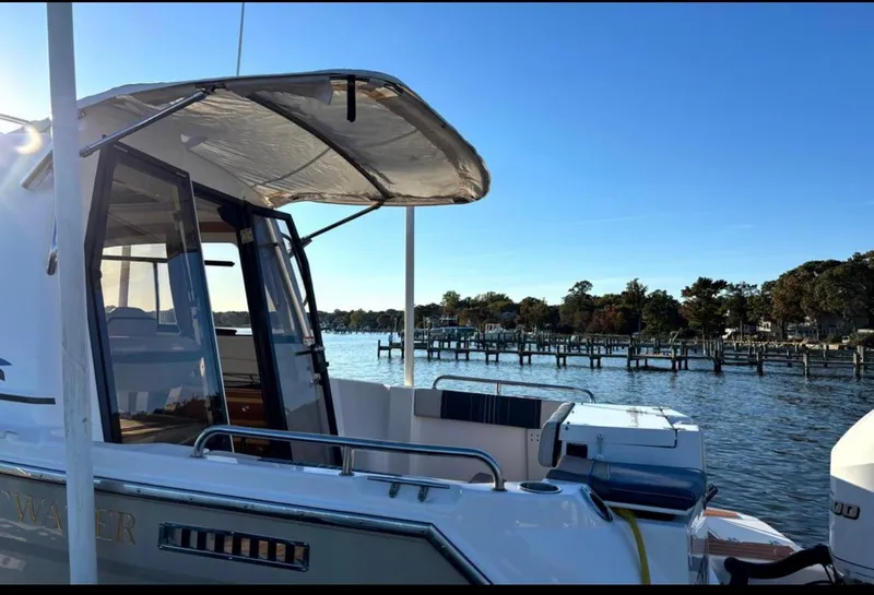 Slide: The Image of 2019 Cutwater C-242 Coupe boat docked by a scenic waterfront. - 3