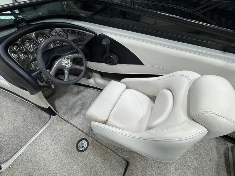 Slide: The Image of 2006 Crownline 21 Classic boat interior with steering wheel and dashboard controls. - 13