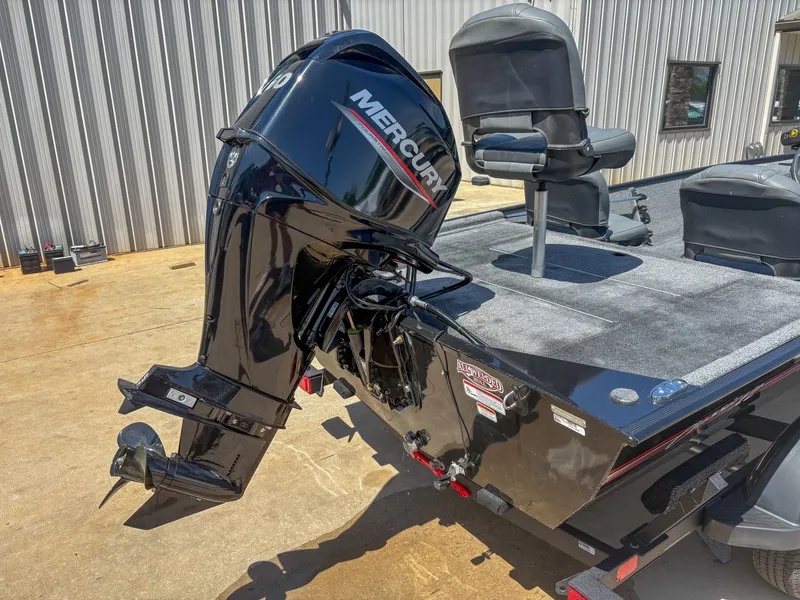 Slide: The Image of 2023 Bass Tracker Classic XL boat with Mercury outboard motor, parked outside a metal building. - 10