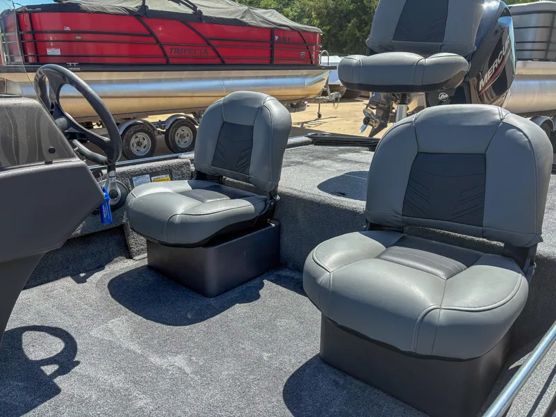 Slide: The Image of 2023 Bass Tracker Classic XL boat interior with gray seating and steering wheel. - 7