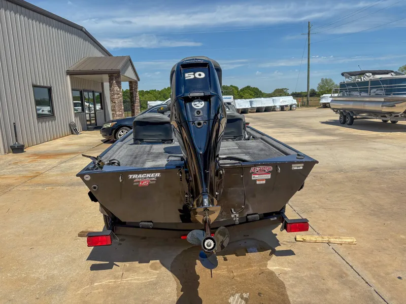 Slide: The Image of 2023 Bass Tracker Classic XL boat with 50 HP motor, parked outdoors. - 9