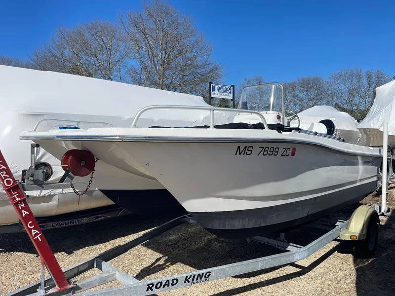 Slide: The Image of 2011 Carolina Cat 18CC boat on trailer, parked outdoors under clear blue sky. - 0