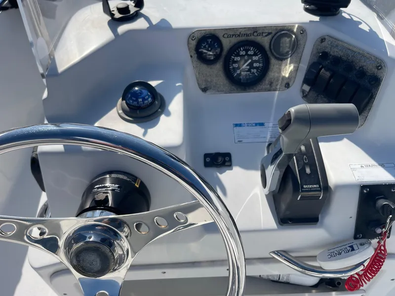 Slide: The Image of Steering console of a 2011 Carolina Cat 18CC boat with controls and gauges. - 10
