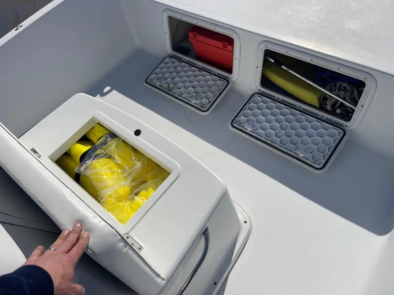 Slide: The Image of Storage compartments on a 2011 Carolina Cat 18CC boat, containing safety equipment and supplies. - 15