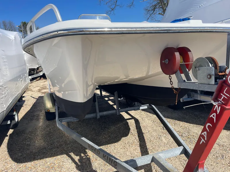 Slide: The Image of 2011 Carolina Cat 18CC boat on trailer, parked outdoors under clear blue sky. - 2