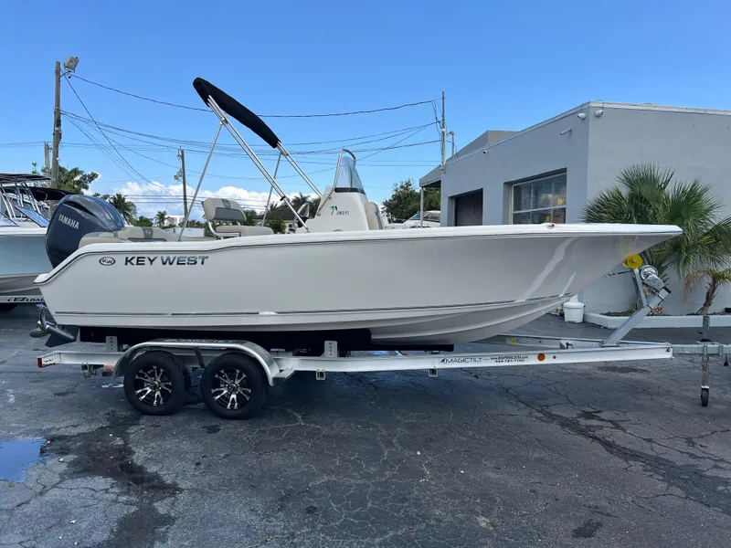 Slide: The Image of 2025 Key West 203 FS boat on trailer, parked outdoors near a building. - 1