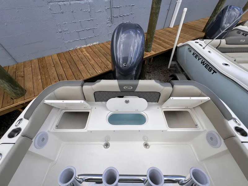 Slide: The Image of 2025 Key West 203 FS boat interior with motor, rod holders, and seating. - 11