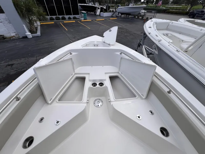 Slide: The Image of 2025 Key West 203 FS boat deck with open storage compartments and cup holders. - 16