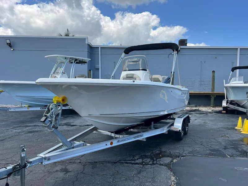 Slide: The Image of 2025 Key West 203 FS boat on trailer, parked outdoors under cloudy sky. - 2