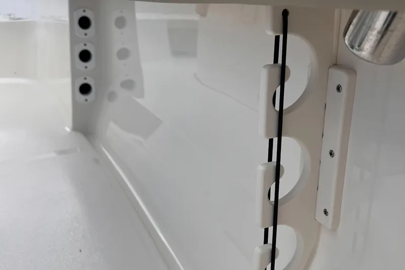 Slide: The Image of 2025 Key West 203 FS boat interior detail with rod holders and sleek white finish. - 20