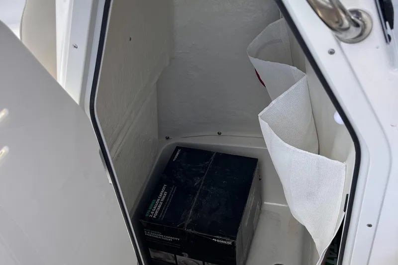 Slide: The Image of Storage compartment in a 2025 Key West 203 FS boat, featuring a box and mesh pockets. - 21