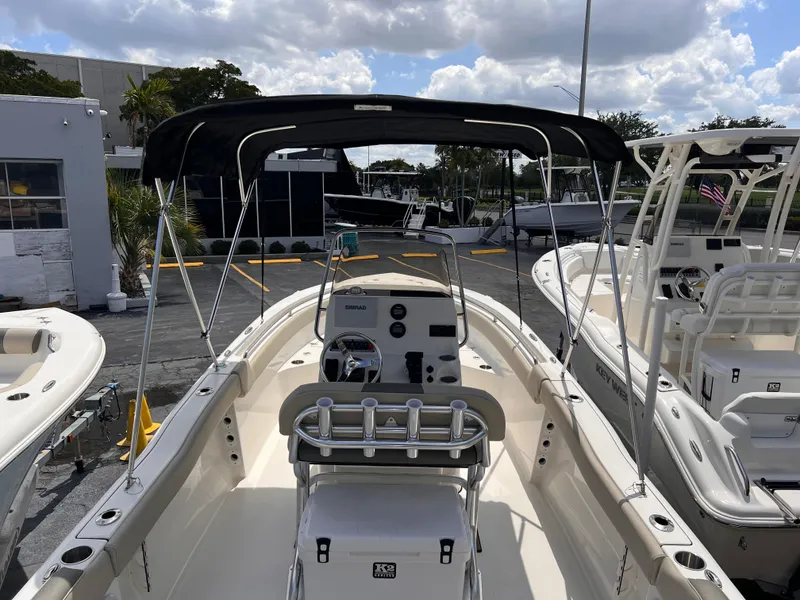 Slide: The Image of 2025 Key West 203 FS boat with canopy, parked at a marina under a cloudy sky. - 26
