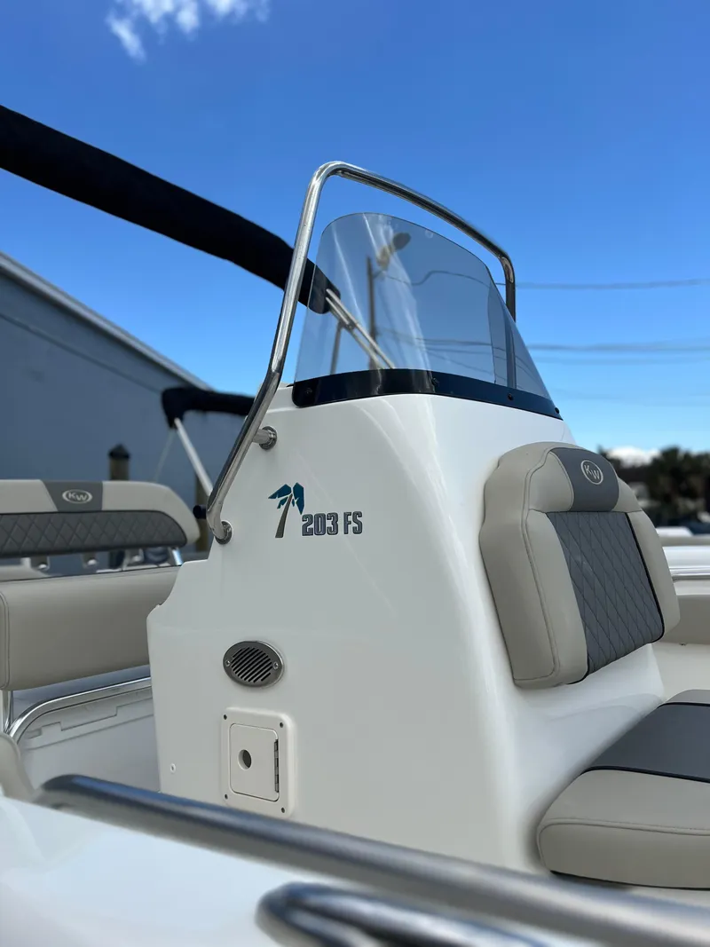 Slide: The Image of 2025 Key West 203 FS boat console with seating, under a clear blue sky. - 27