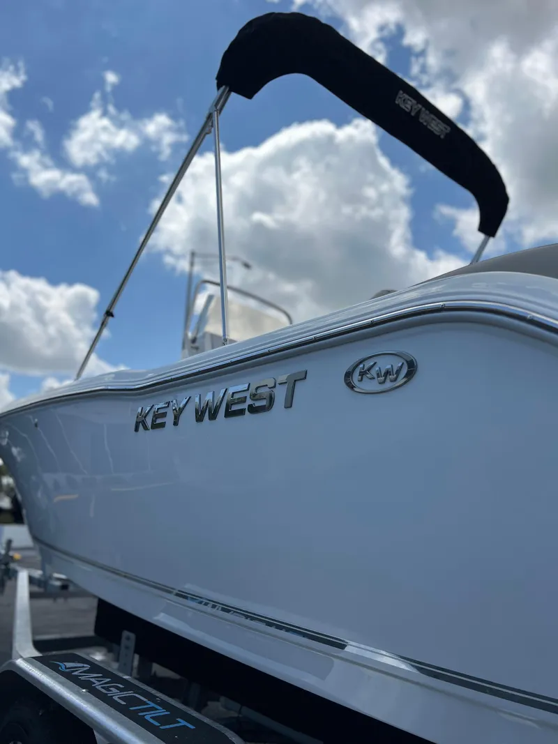 Slide: The Image of 2025 Key West 203 FS boat with sleek design under a cloudy sky. - 28