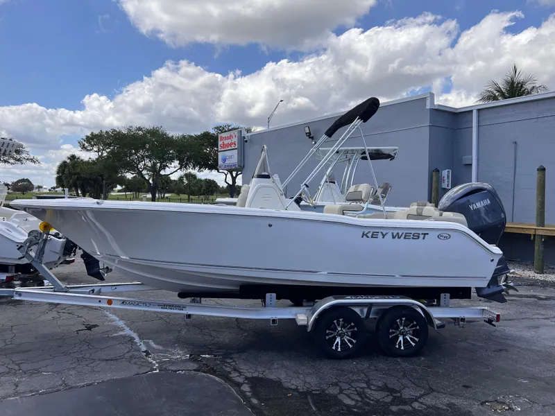 Slide: The Image of 2025 Key West 203 FS boat on trailer, parked outdoors under a cloudy sky. - 3