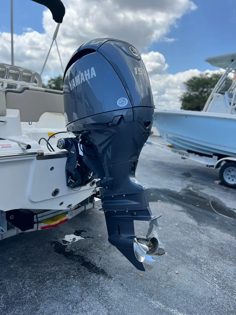 Slide: The Image of 2025 Key West 203 FS boat with Yamaha outboard motor, parked on a sunny day. - 5