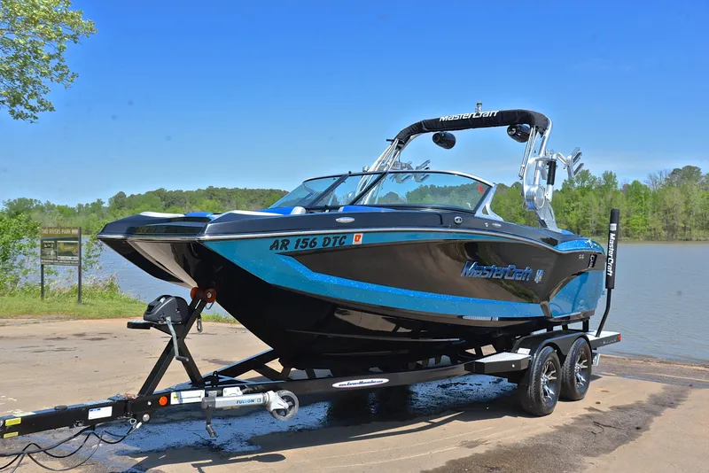 Slide: The Image of 2015 MasterCraft X20 boat on trailer by a lake, ready for water sports. - 10