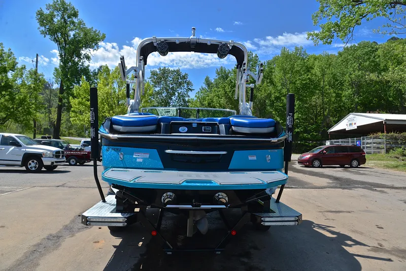 Slide: The Image of 2015 MasterCraft X20 boat, rear view, parked outdoors on a sunny day. - 13