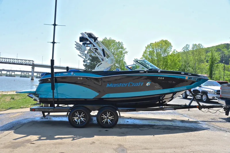Slide: The Image of 2015 MasterCraft X20 boat on trailer near river, ready for water sports. - 15