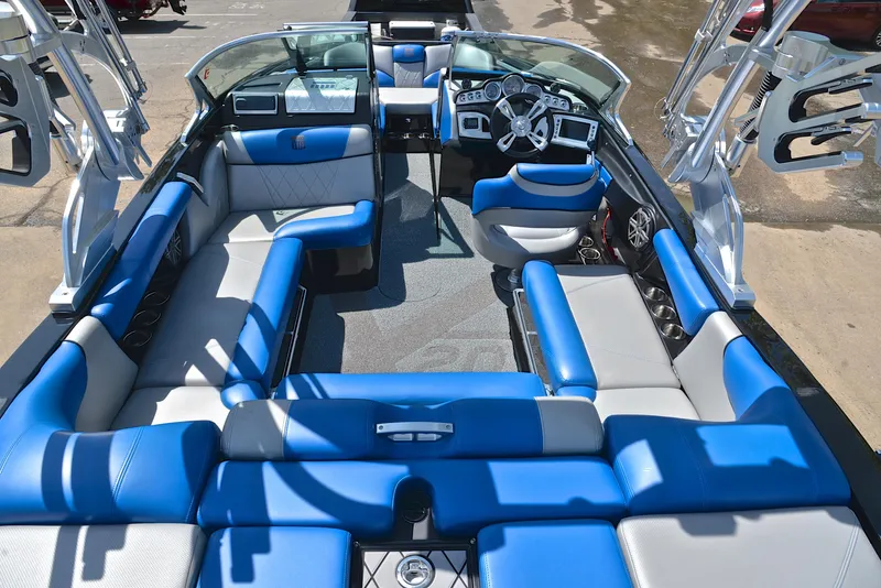 Slide: The Image of 2015 MasterCraft X20 boat interior with blue and gray seating, modern dashboard, and spacious layout. - 18