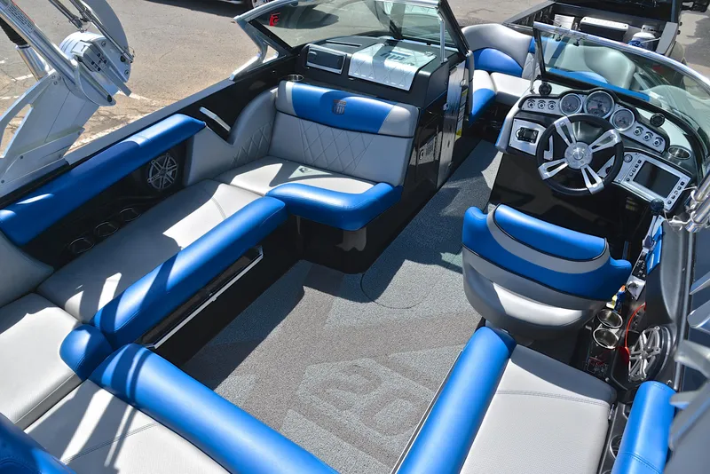 Slide: The Image of 2015 MasterCraft X20 boat interior with blue and gray seating, modern dashboard, and steering wheel. - 19