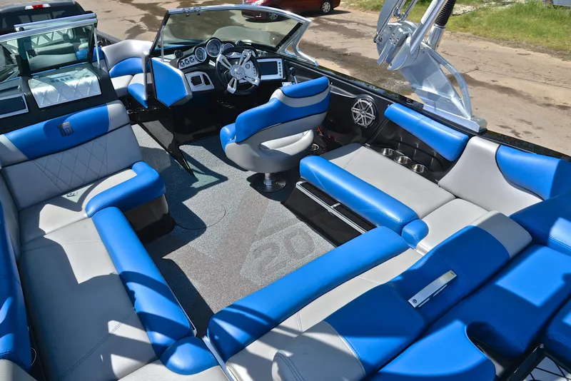 Slide: The Image of 2015 MasterCraft X20 boat interior with blue and gray seating, modern dashboard, and spacious layout. - 20