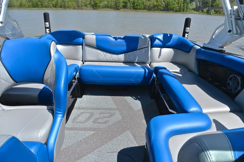 Slide: The Image of Interior of 2015 MasterCraft X20 boat with blue and gray seating on a lake. - 24
