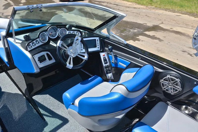 Slide: The Image of 2015 MasterCraft X20 boat interior with blue and gray seating, modern dashboard, and steering wheel. - 25