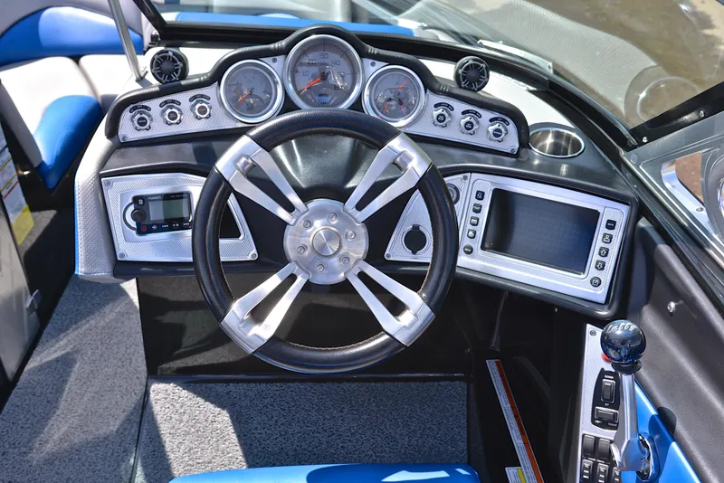 Slide: The Image of 2015 MasterCraft X20 boat dashboard with steering wheel, gauges, and control panel. - 26