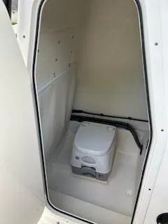 Slide: The Image of 2024 Sea Born LX24 Center Console boat interior with portable toilet. - 13
