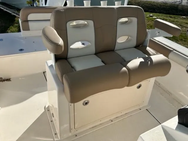 Slide: The Image of 2024 Sea Born LX24 Center Console boat seating with cushioned armrests and storage. - 7