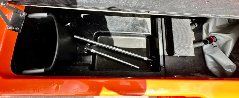 Slide: The Image of Storage compartment of a 2020 Malibu 21VLX boat with metal rods and equipment. - 14