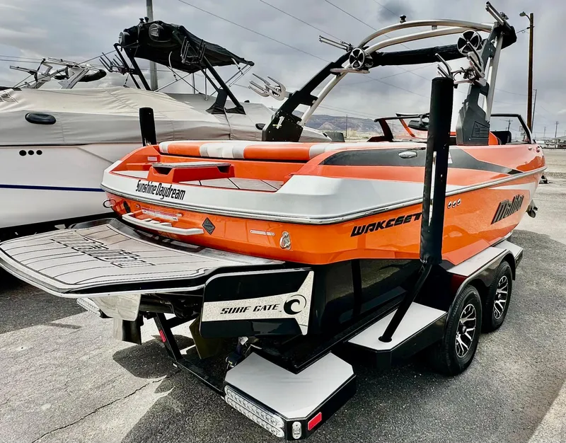 Slide: The Image of 2020 Malibu 21VLX boat in vibrant orange, parked on a trailer, showcasing sleek design and features. - 3