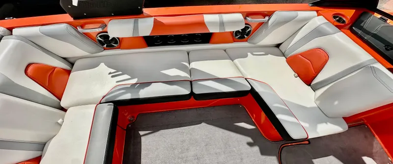 Slide: The Image of 2020 Malibu 21VLX boat interior with orange and gray seating, featuring modern design and spacious layout. - 7