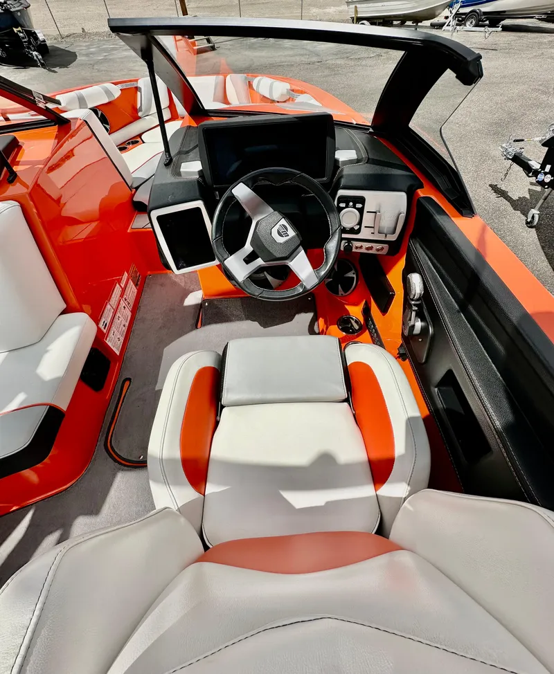 Slide: The Image of 2020 Malibu 21VLX boat interior with orange and white seating, modern dashboard, and steering wheel. - 9