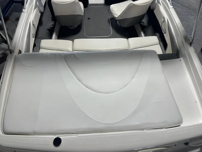 Slide: The Image of 2008 Bayliner 185 boat interior with white seating and carpeted floor. - 12