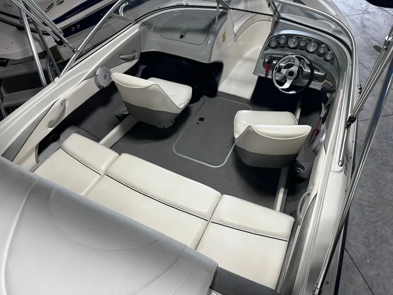 Slide: The Image of 2008 Bayliner 185 boat interior with white seating and steering console. - 13